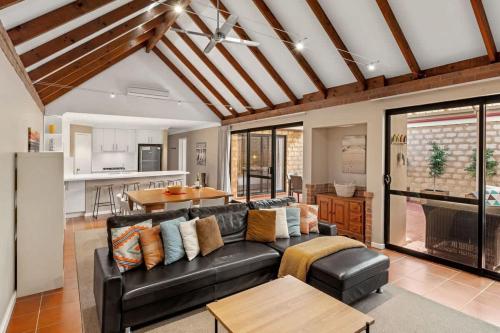 a living room with a black couch and a table at Clearwater - Cosy Comforts Steps from the Beach in Dunsborough