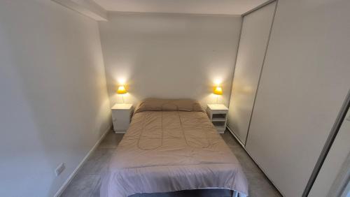 a small bedroom with two beds and two lamps at La Escondida in Chascomús