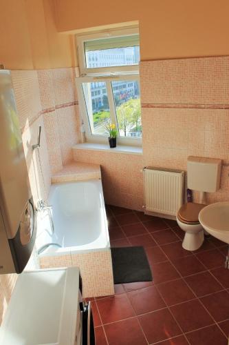 a bathroom with a tub and a toilet and a sink at Lidi Guesthouse in Budapest