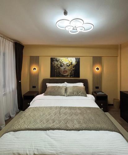 a bedroom with a large bed with a painting on the wall at Green Escape in Slănic-Moldova