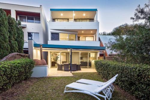 a white bench in front of a house at 'Azure' Beachside Resort Escape for Groups in Marybrook
