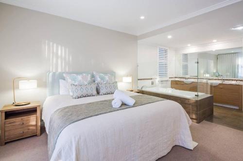 a bedroom with a large bed and a bath tub at 'Azure' Beachside Resort Escape for Groups in Marybrook