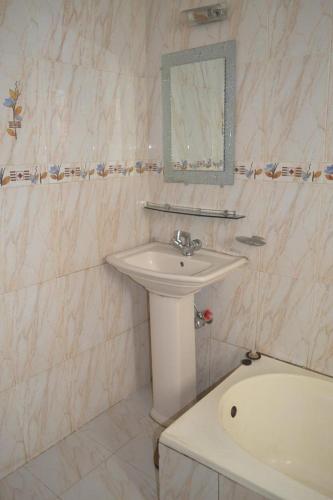a bathroom with a sink and a toilet and a tub at Hotel Shams Plaza in Cox's Bazar