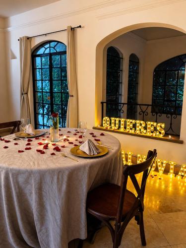 a table with a white table cloth and roses on it at Hotel San Jose Centro Historico in San Luis Potosí