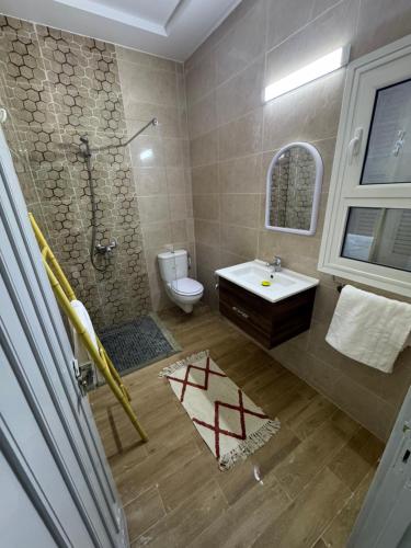 a bathroom with a shower and a toilet and a sink at Villa Mazzyd in Temlale