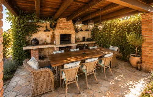 an outdoor kitchen with a wooden table and chairs at Villa Novel in Višnjan