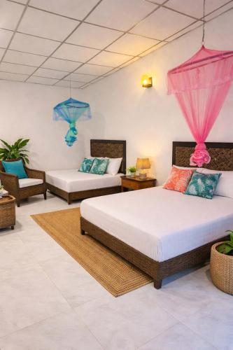 a bedroom with two beds and two chairs at Marina Safari Resort Udawalawe in Udawalawe