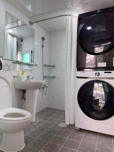 a bathroom with a washing machine and a sink at 1&2stayㅡH in Tongdaegu-yŏk
