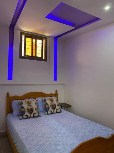 a bedroom with a bed with a blue ceiling at Appartement au centre de TIZNIT in Tiznit