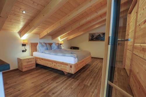 a bedroom with a bed in a room with wooden floors at Haus Hochlenzerblick in Schönau am Königssee