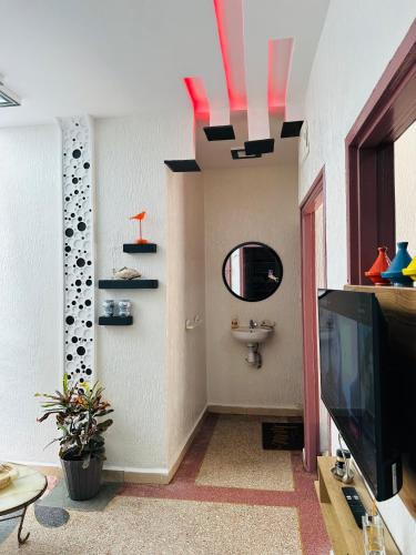 a living room with a television and a sink at Appartement au centre de TIZNIT in Tiznit
