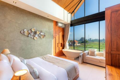 a bedroom with a tub and a bed and a window at Duality Villas in Ubud