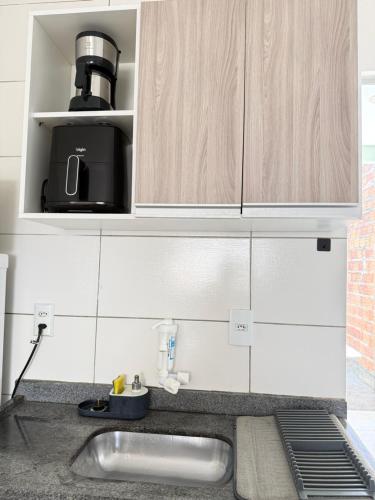 a kitchen counter with a sink and a microwave at Casa parque 18 in Araguaína