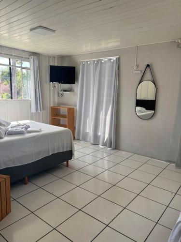 a bedroom with a bed and a tiled floor at Cantinho da Nonna in Morretes