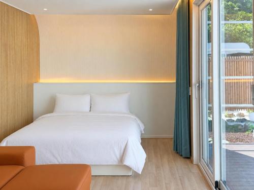 a bedroom with a bed and a window at 담양 다움 스파 빌리지 in Haktong-ni