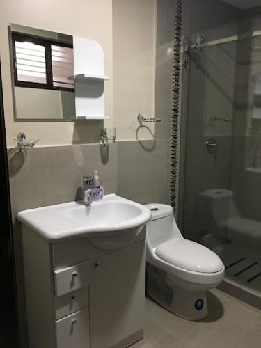 a white bathroom with a sink and a toilet at HOTEL en el CENTRO HISTORICO in Cuenca