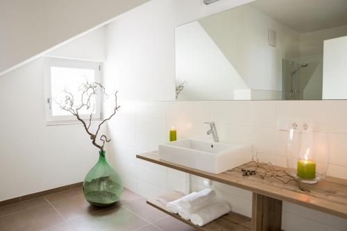a bathroom with a sink and a vase with candles at Ferienwohnungen Hochbrunner in Terlano