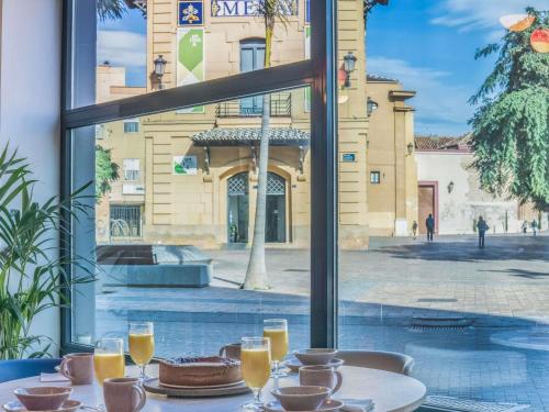 a table with a cake and glasses of orange juice at Novotel Suites Malaga Centro in Málaga