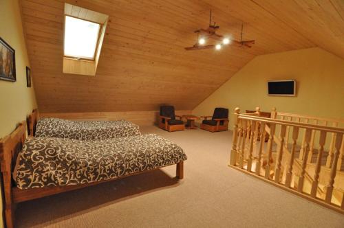 a attic room with a bed and a staircase at Dayarta in Skhidnitsa