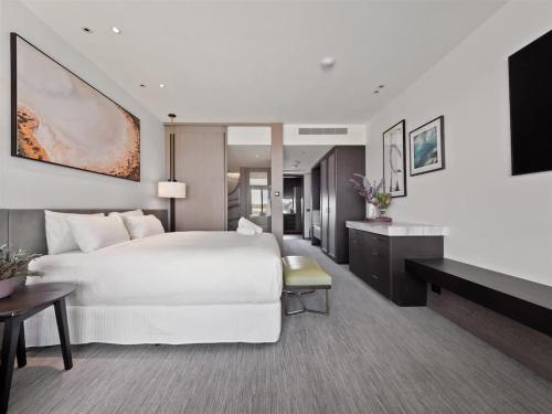 a hotel room with a large white bed and a television at Samphire Chalet Peppermint - Experience Eco-Luxury in Geographe