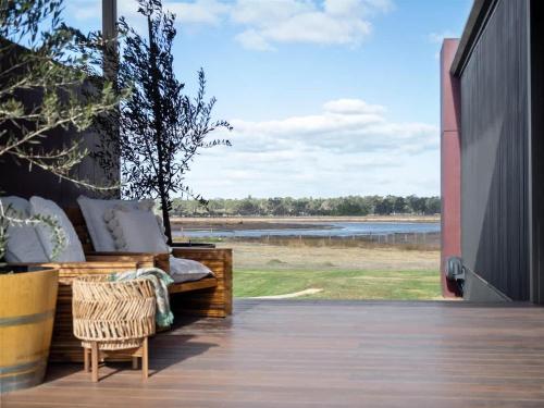 a porch with a couch and a view of a lake at Samphire Chalet Peppermint - Experience Eco-Luxury in Geographe