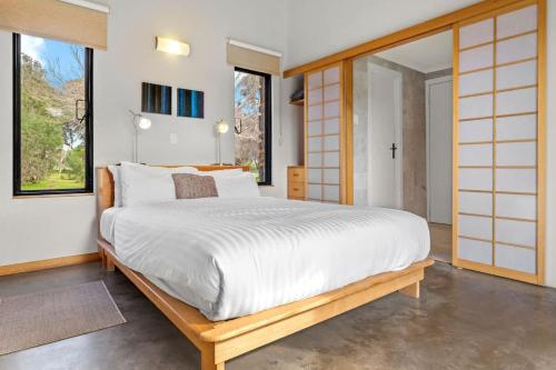 a bedroom with a large white bed and windows at Petra Olive 2 in Yallingup