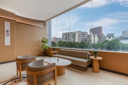 a living room with a couch and a large window at GH Hotel in Chengdu