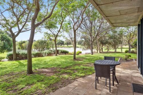 a table and chairs on a patio with a view of a park at Petra Olive 5 in Yallingup