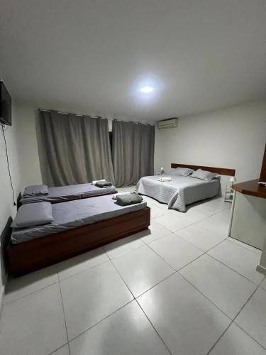 a bedroom with two beds and a window at Pousada Boa Praia Guriri in São Mateus