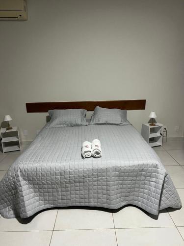 a bedroom with a bed with two slippers on it at Pousada Boa Praia Guriri in São Mateus