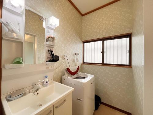 a bathroom with a sink and a washing machine at Masugataya Ryokan in Tako