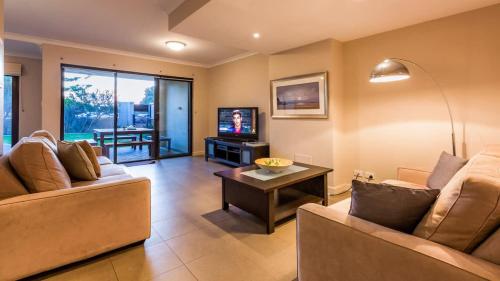 a living room with two couches and a television at Surfside 8 - Spacious Retreat on Yallingup Beach in Yallingup
