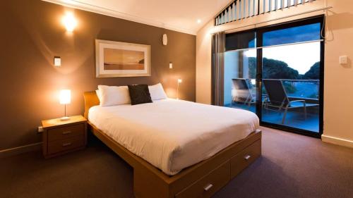 a bedroom with a large bed and a balcony at Surfside 8 - Spacious Retreat on Yallingup Beach in Yallingup