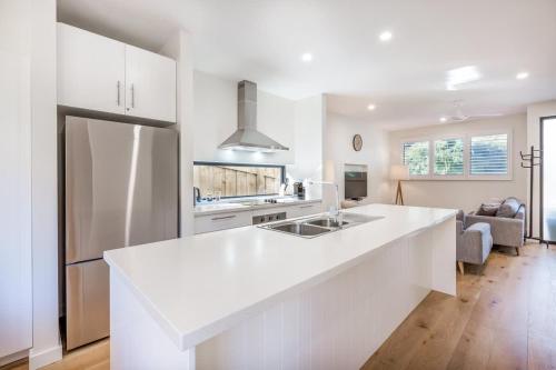 a white kitchen with a large white counter top at Yallingup Lagoon Beach House in Yallingup