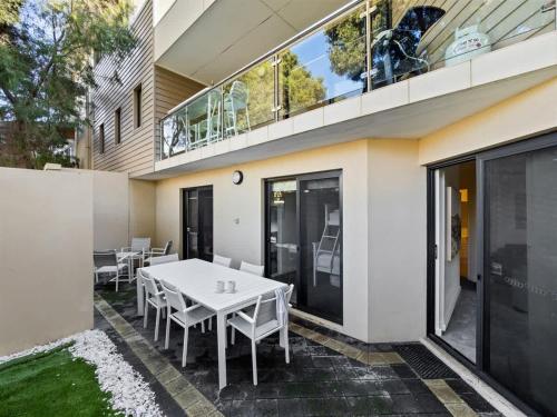 a patio with a white table and chairs on a building at Surfside 1 - An Unforgettable Yallingup Experience in Yallingup