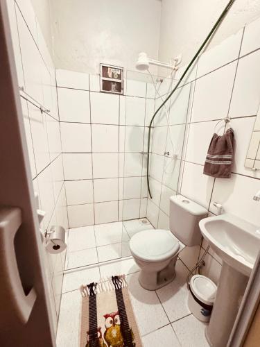 a white bathroom with a toilet and a sink at Pousada e Hostel das Rosas in Barreirinhas