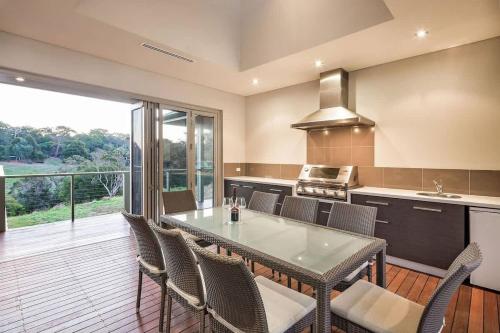 a kitchen with a table and chairs and a large window at Valley Views - Elevated Hilltop Escape near Beaches in Yallingup
