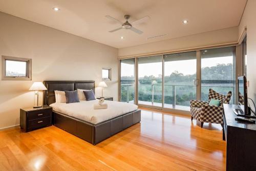 a large bedroom with a bed and a couch and windows at Valley Views - Elevated Hilltop Escape near Beaches in Yallingup