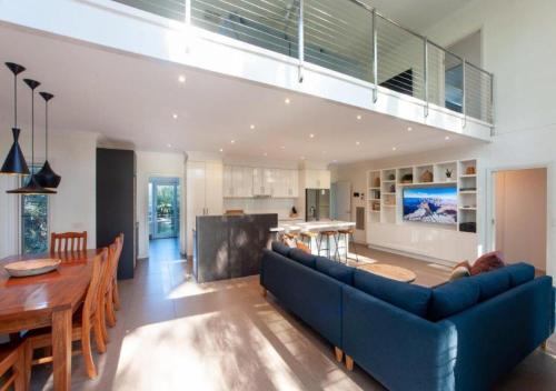 a living room and kitchen with a blue couch and a table at The Gums - Echuca Holiday Homes in Echuca