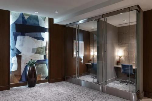 a lobby with a glass partition with a vase at Hanover Post Oak in Houston