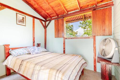 a bedroom with a bed and a fan and a window at Cabaa el Sol Medellin in Titiribí