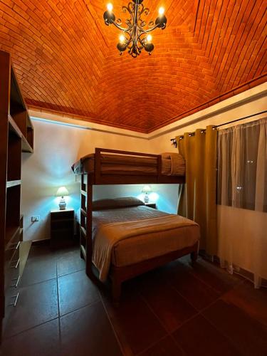 a bedroom with a bed and a ceiling with a chandelier at Casa Granada in Guanajuato