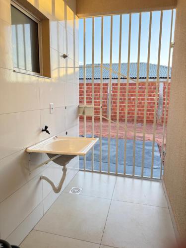 a bathroom with a sink and a large window at Casa 20 in Araguaína