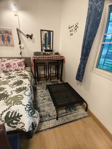a living room with a bed and a table at บ้านสุขสันต์ พฤกษา45 บางใหญ่ in Ban Nong Kradi