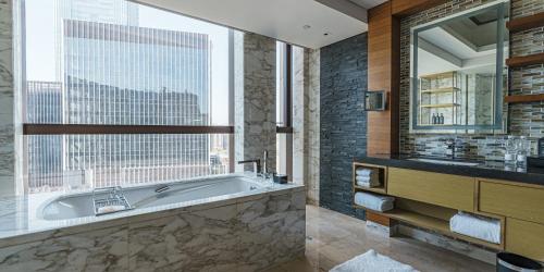 a bathroom with a tub and a large window at Sheraton Beijing Lize Hotel in Beijing