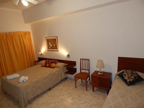 a hotel room with two beds and a chair at Complejo turistico ALOJARTUR in San Rafael