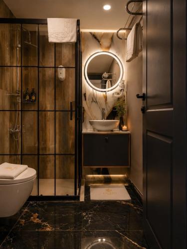 a bathroom with a toilet and a sink and a mirror at Asgard Hotel in Beylikduzu