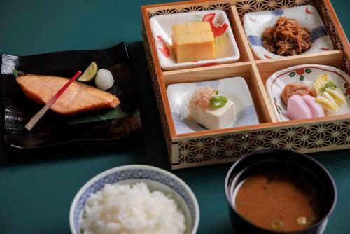 a table topped with plates of food and a bowl of rice at Four Seasons Hotel Tokyo at Marunouchi in Tokyo