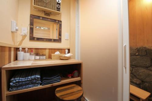 a small bathroom with a cupboard with towels and a mirror at 千年乃宿 in Kubo