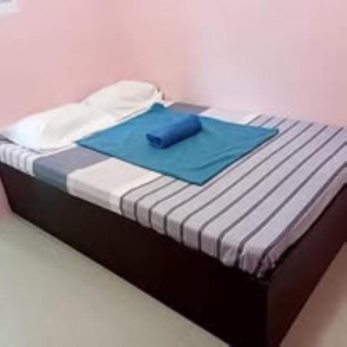 a bed with a blue towel on top of it at Walk Inn Dipolog City by RedDoorz in Dipolog
